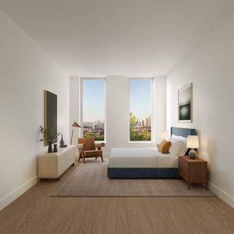 A bedroom with a large bed, a chair, and a window overlooking a cityscape.