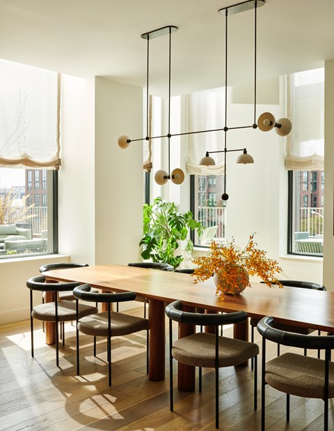 A dining room with a wooden table and chairs.