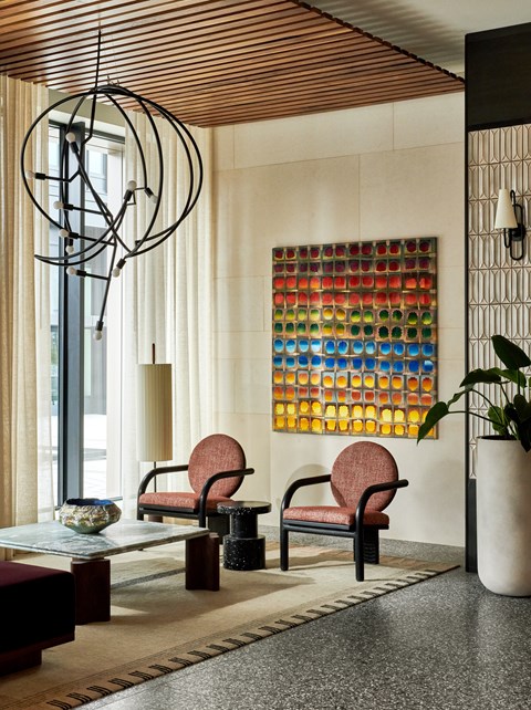 A room with a chair, a table and a lamp.