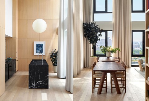 A modern dining room with a wooden table and chairs.
