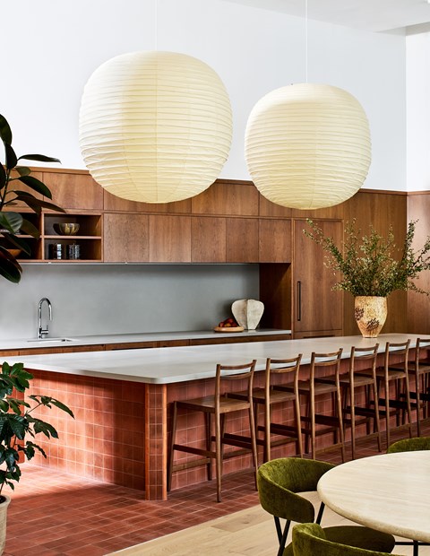 A kitchen with a long table and chairs.
