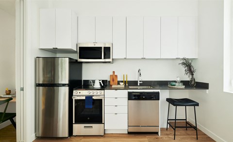 a kitchen with white cabinets and stainless steel appliances