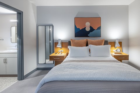 A bedroom with a large bed and a painting on the wall.