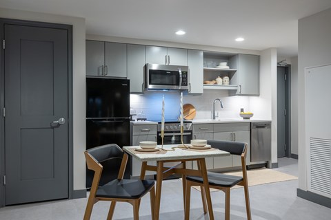 A modern kitchen with a dining table set for two.