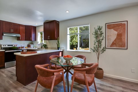 A kitchen with a table and chairs in the middle of the room.