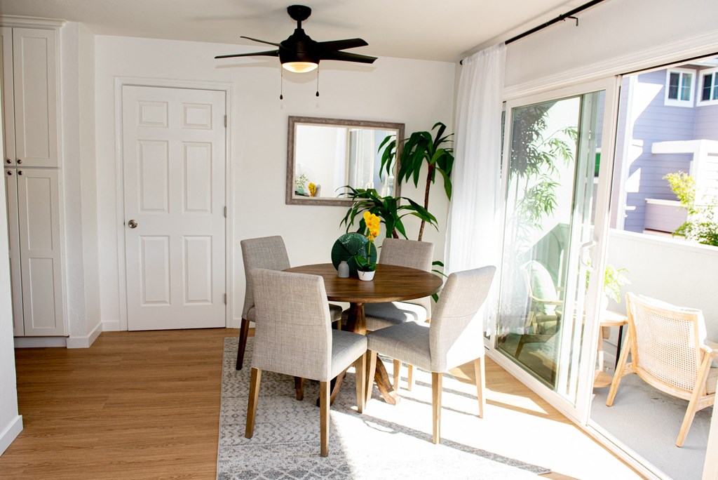 a dining room with a table and chairs and a ceiling fan