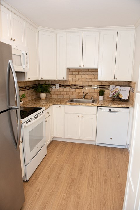 a kitchen with white cabinets and a sink and a refrigerator