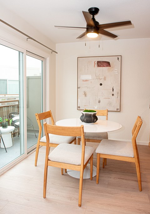 A dining room with a white table and chairs.