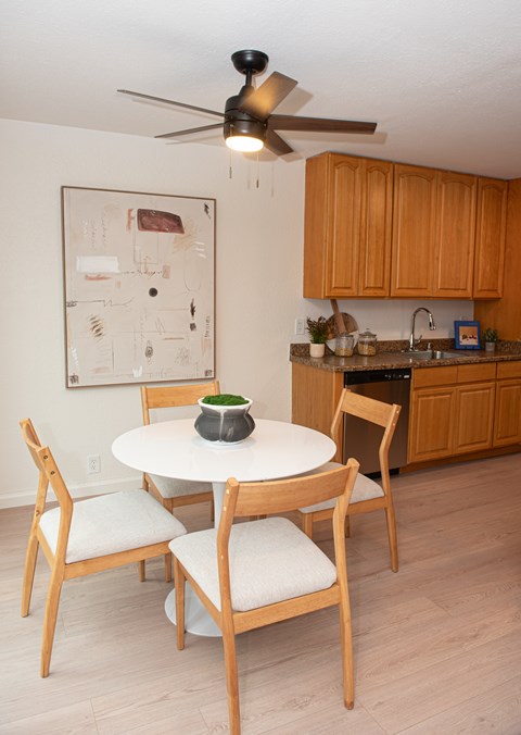A kitchen with a table and chairs.