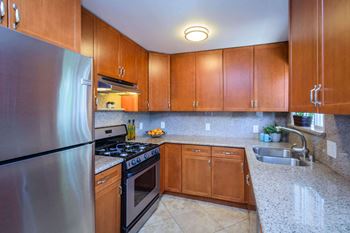 A kitchen with wooden cabinets and granite countertops.