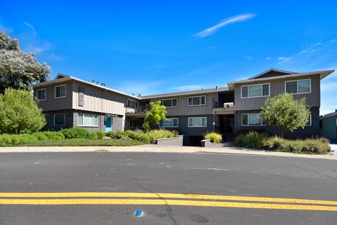 A large apartment complex with a parking lot in front.
