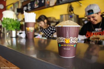 A cup of coffee from Shizuku Coffee is on a counter.
