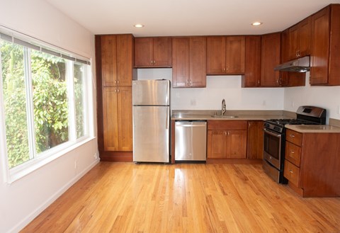 A kitchen with wooden cabinets and a stainless steel refrigerator.