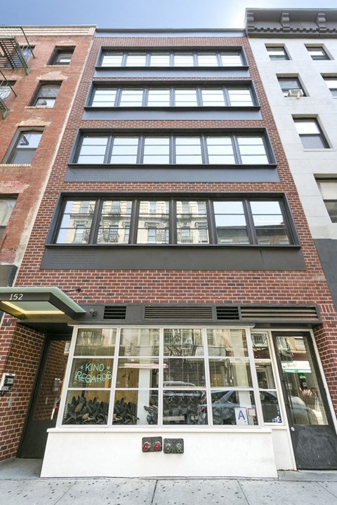 A brick building with a storefront that has a sign that says "KIND".