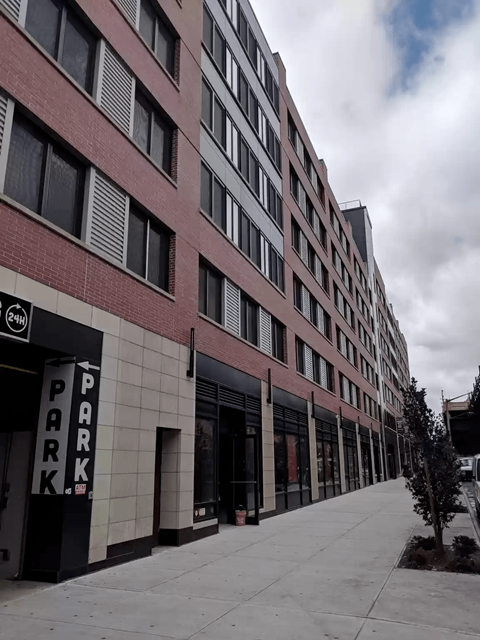 A tall building with a parking sign on the ground.