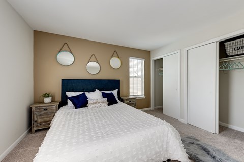 A bedroom with a large bed and a wooden nightstand.