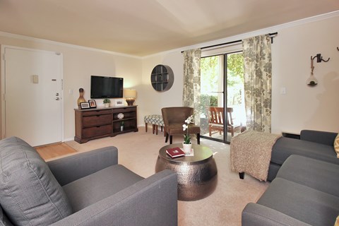 A living room with grey couches and a wooden coffee table.
