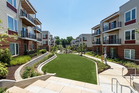 A grassy area in front of apartment buildings.