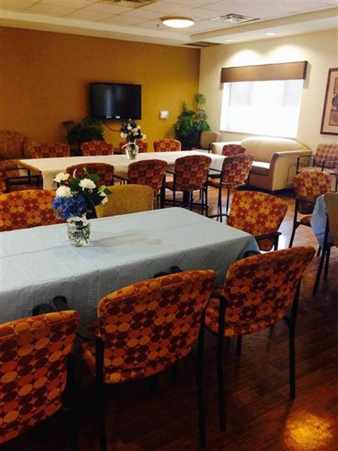 A dining room with a table set for a meal.