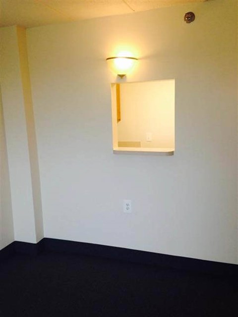 A wall with a mirror and a light on it.