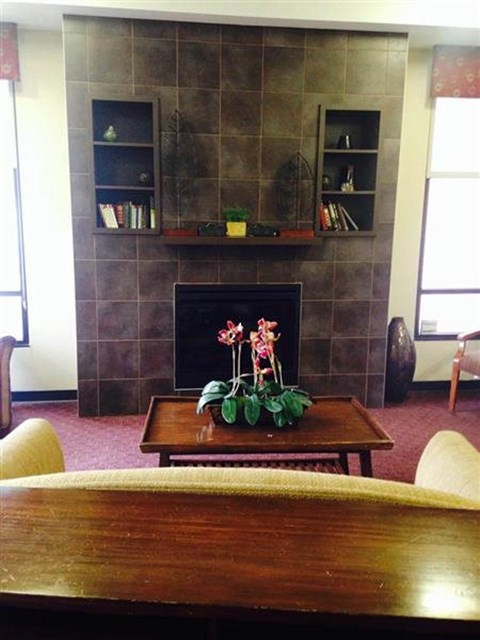 A room with a fireplace and a table in front of it.