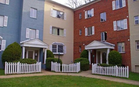 Apartment complex with white picket fences in front of each building.