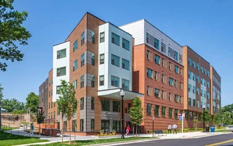 A modern multi-story building with a mix of brick and glass facade.