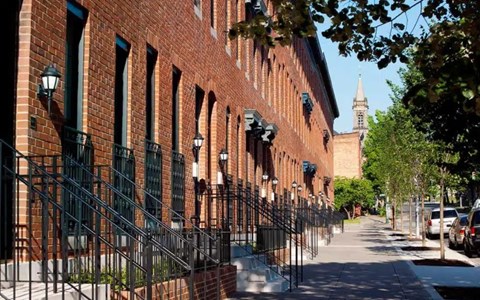 A long brick building with a tower in the background.