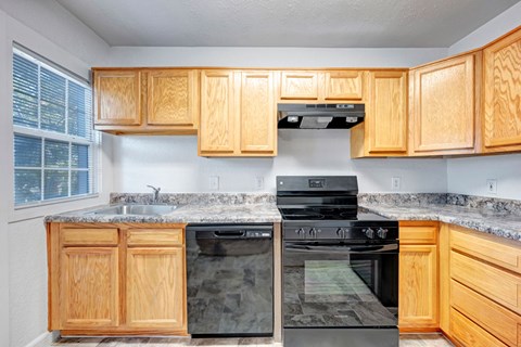 A kitchen with wooden cabinets and black appliances.