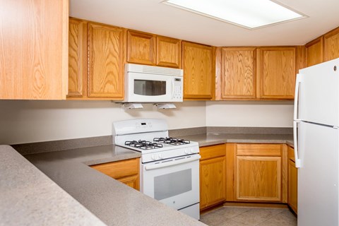 A kitchen with wooden cabinets and white appliances.