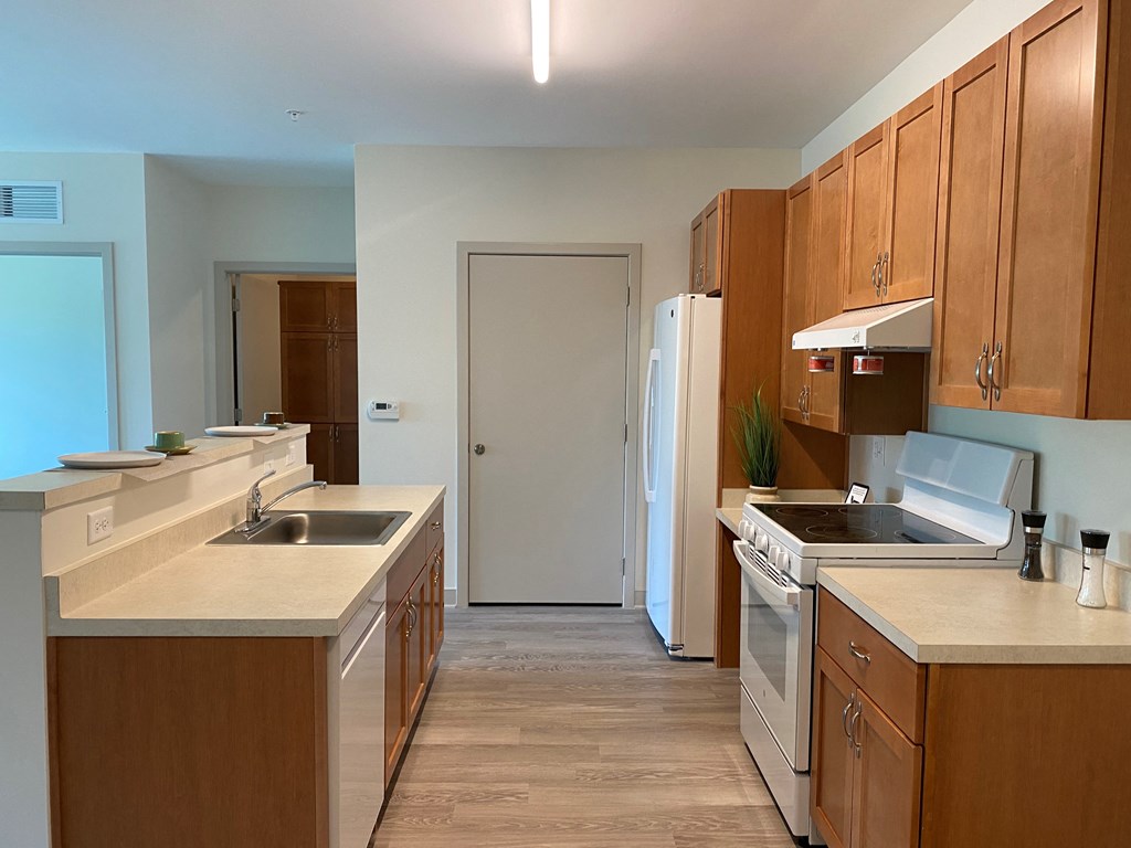 an empty kitchen with wooden cabinets and a white refrigerator