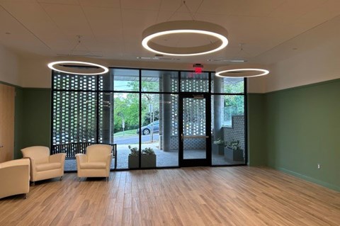 A waiting room with a green wall and a wooden floor.