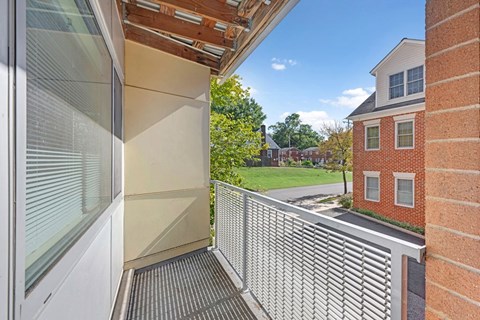 A balcony with a metal railing and a glass door.