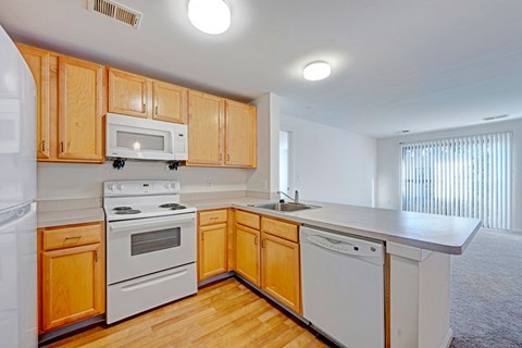 A kitchen with wooden cabinets and white appliances.
