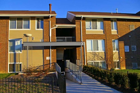A brick apartment building with a black gate in front.