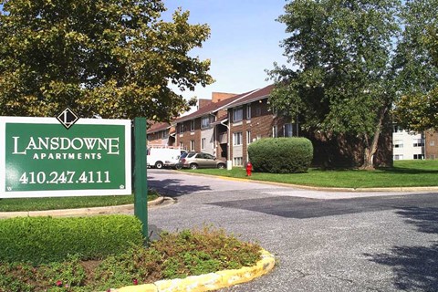 A green sign for Lansdowne Apartments with a phone number on it.