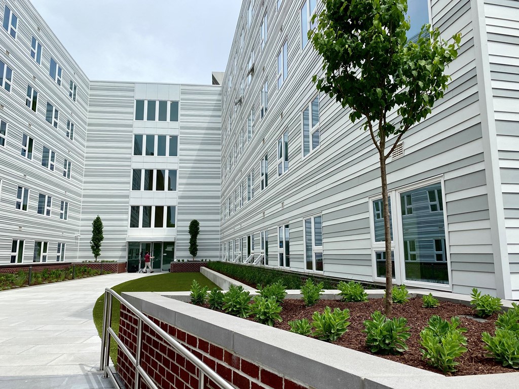 a view of the exterior of an apartment building with a garden