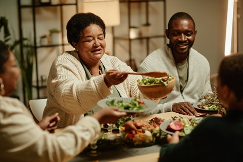 A group of people are gathered around a table enjoying a meal together.