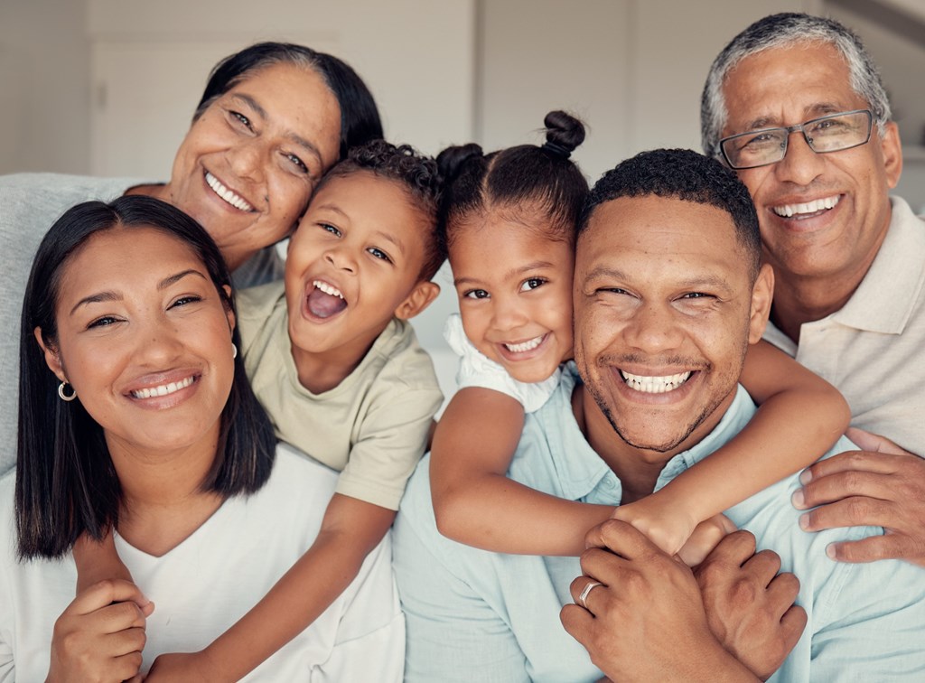 A family of five is smiling and hugging together.