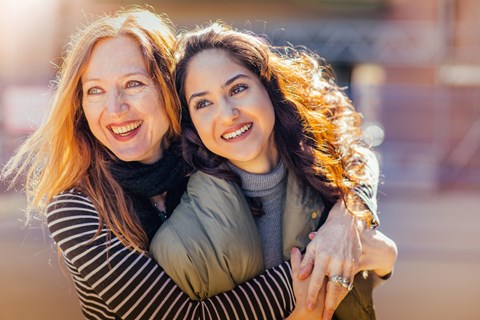 Two women hugging each other in an outdoor setting.