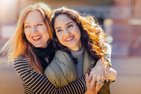 Two women hugging each other in an outdoor setting.