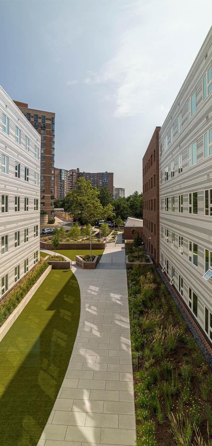 a view of a courtyard with buildings and grass