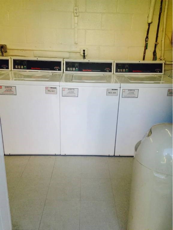 A row of washing machines are lined up in a laundromat.