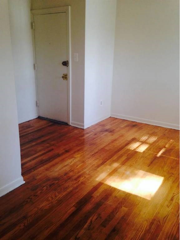 A room with a wooden floor and a white door.