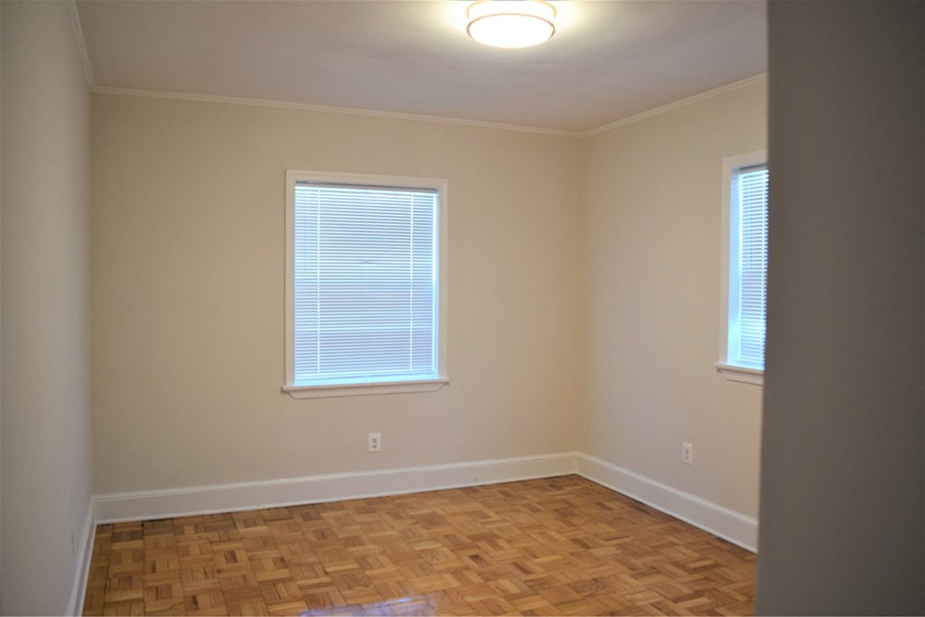 A room with a window and wooden flooring.