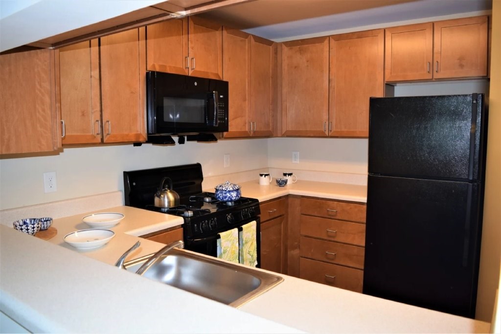 A black stove top oven with a kettle on it.