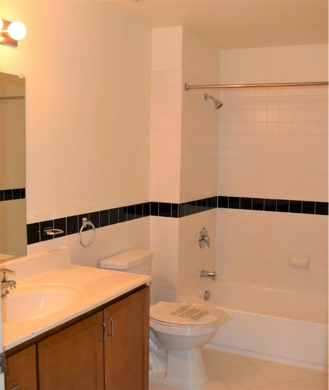 A white toilet with a white sink and a white bathtub in a bathroom.
