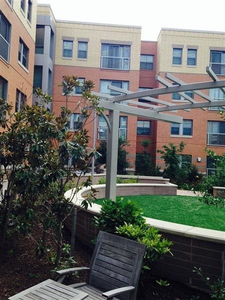 A patio with a table and chairs is in front of a building.