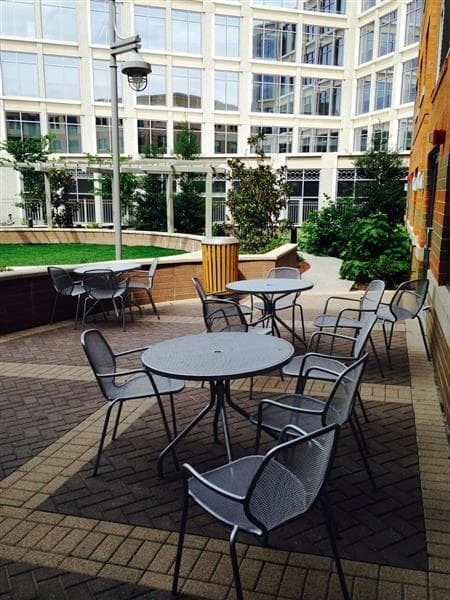 A patio with a table and chairs is surrounded by a brick wall.