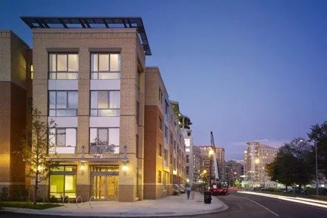 A modern building with a glass entrance and a lit up sign that says "The".